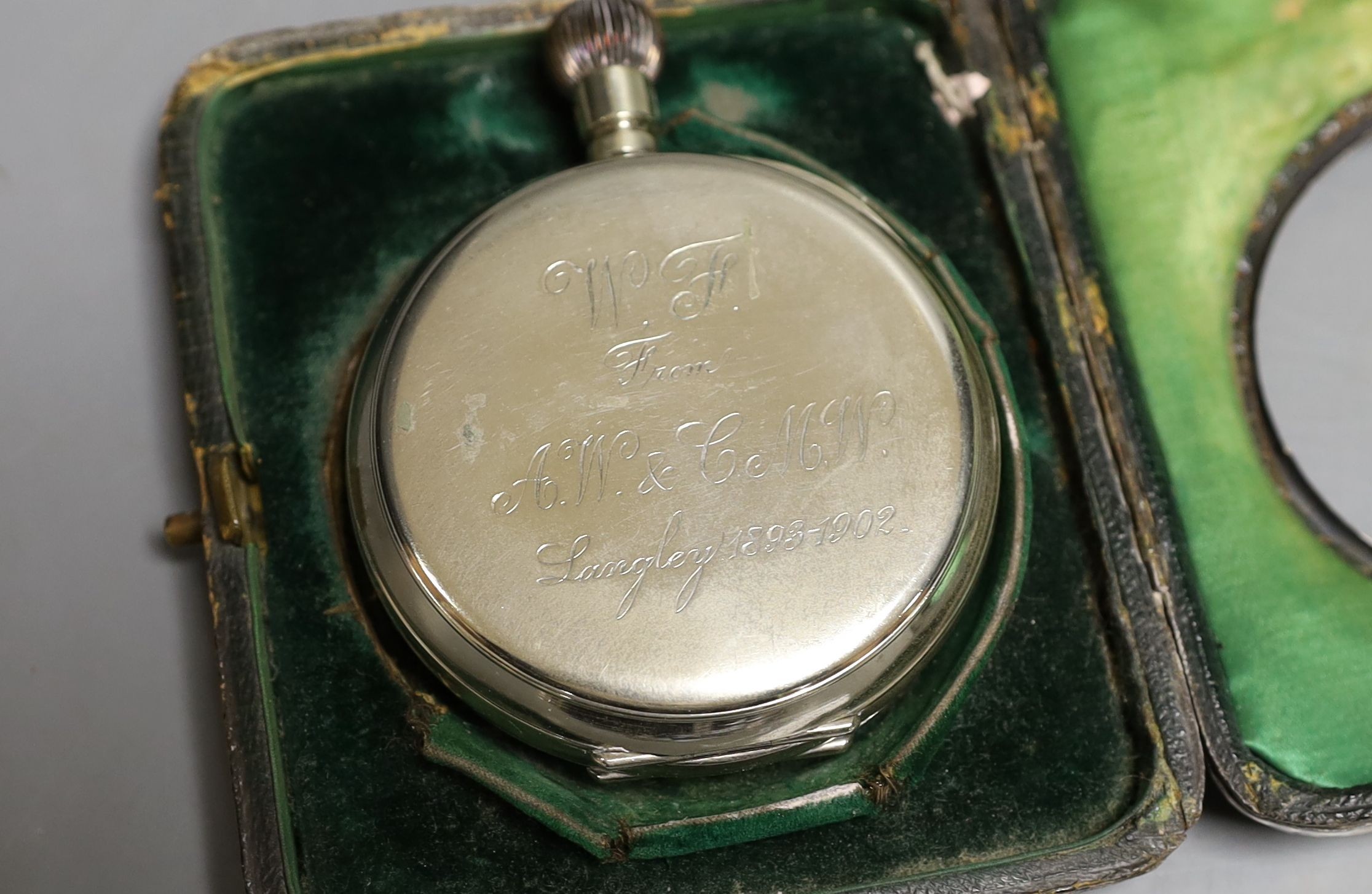 An early 20th century hammered silver mounted travelling watch case, marks rubbed, with keyless Goliath pocket watch.